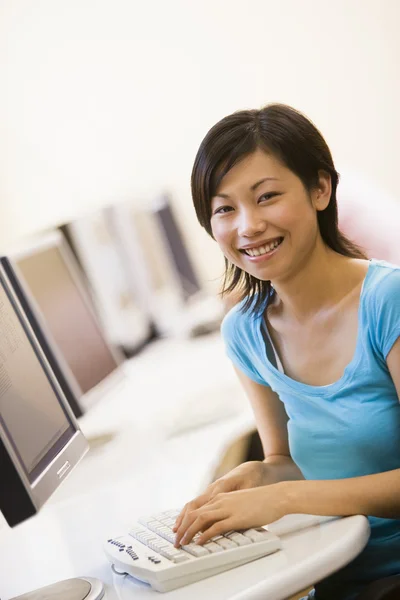 女人坐在电脑室打字和微笑 — 图库照片