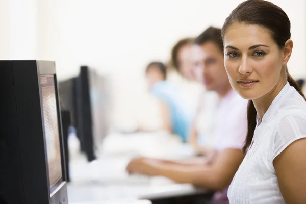 Žena sedí v počítačové učebně s pozadí — Stock fotografie