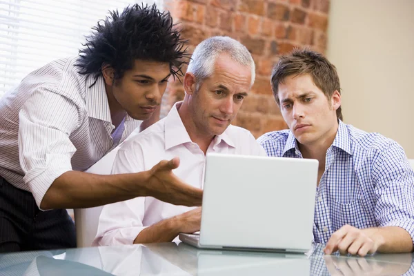 三个商人坐在办公室用的笔记本电脑 — 图库照片