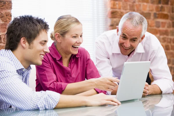 Trzy Biznesmeni Biurze Laptopa Wskazując Śmiejąc Się — Zdjęcie stockowe