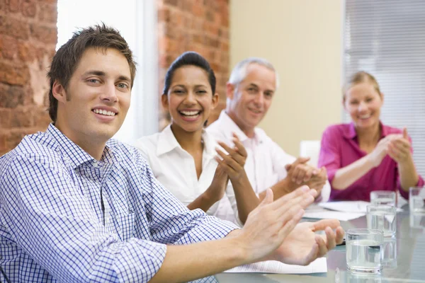 Quatro empresários na sala de reuniões aplaudindo e sorrindo — Fotografia de Stock