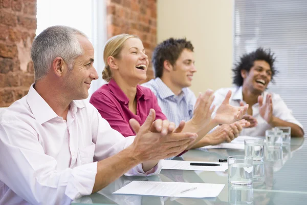Cuatro empresarios en la sala de juntas aplaudiendo y sonriendo —  Fotos de Stock