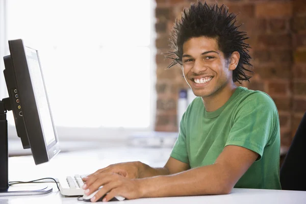 商人在办公室电脑微笑上键入 — 图库照片