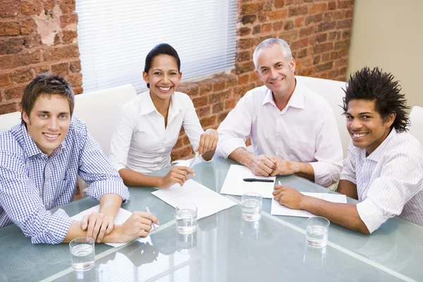 Fyra företagare i styrelserummet leende — Stockfoto