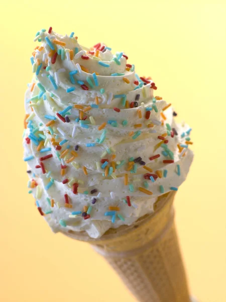 Cône de crème glacée fouettée avec des bonbons saupoudrer — Photo