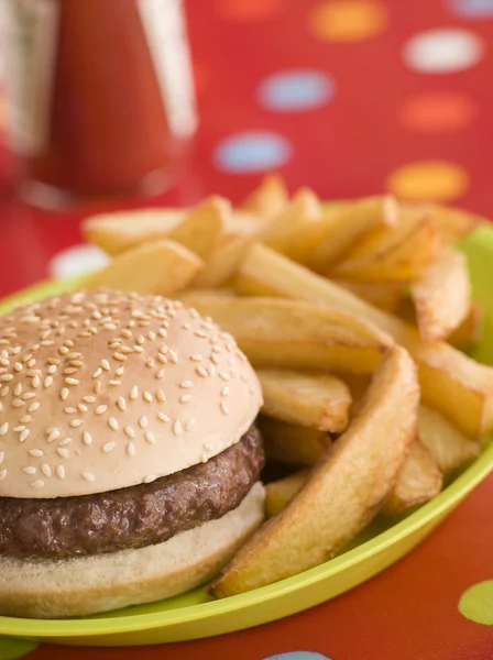 Beefburger im Sesamkernbrötchen mit klobigen Chips — Stockfoto
