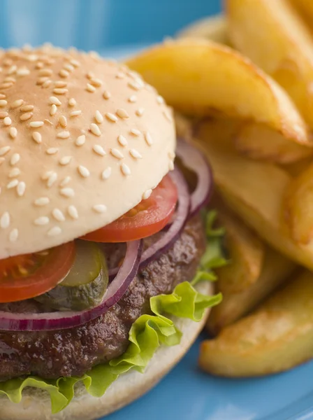 Beefburger mit Salat und Essiggurken im Sesambrötchen mit Chips — Stockfoto