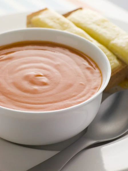 Чаша томатного супа с сырными поджаренными солдатами — стоковое фото