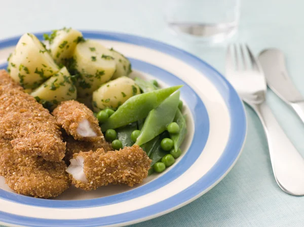 Kyckling goujons med ört smörade färskpotatis och gröna vegeta — Stockfoto