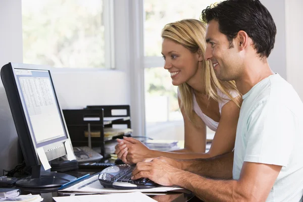 ホーム オフィスのコンピューターを使用し、笑みを浮かべてのカップル — ストック写真