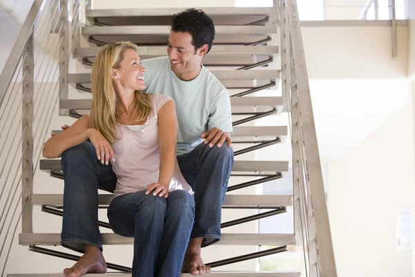 Casal sentado na escada sorrindo — Fotografia de Stock