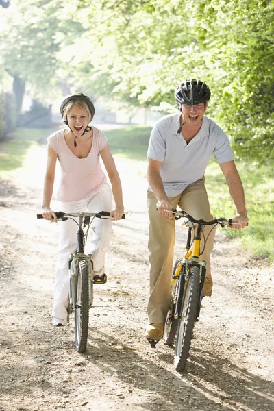 Couple on bikes outdoors smiling — Stock Photo, Image