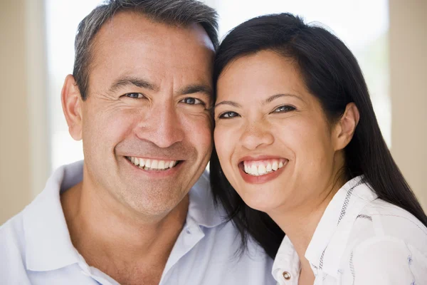 Par i vardagsrummet leende — Stockfoto