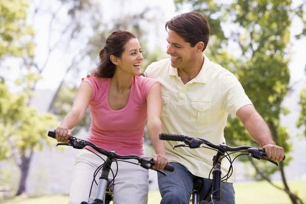 Пара на велосипедах на улице улыбается — стоковое фото