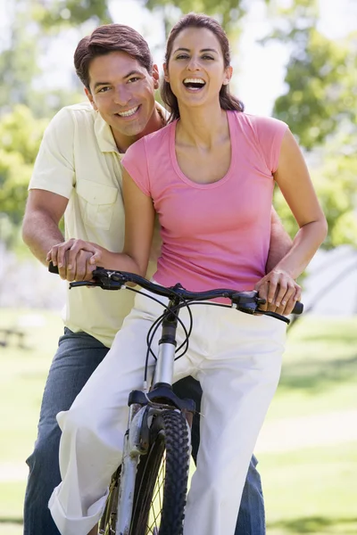 Couple sur un vélo en plein air souriant — Photo