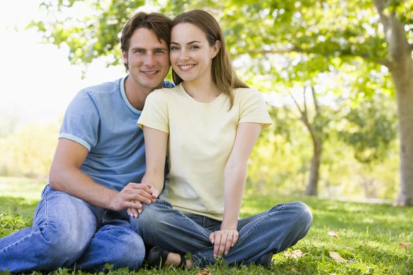 Paar sitzt lächelnd im Freien — Stockfoto