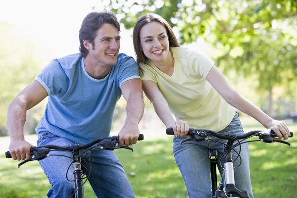 Couple sur des vélos en plein air souriant — Photo
