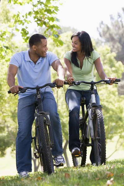 Para na rowery na zewnątrz uśmiechający się — Zdjęcie stockowe