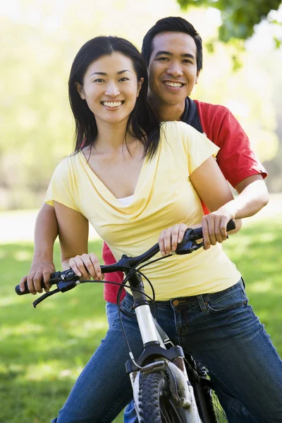 Пара на велосипеде на улице улыбается — стоковое фото