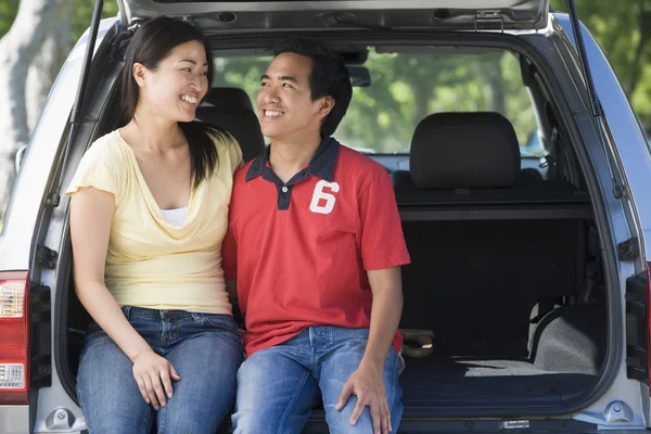 Пара сидящих на заднем сиденье фургона улыбающихся — стоковое фото