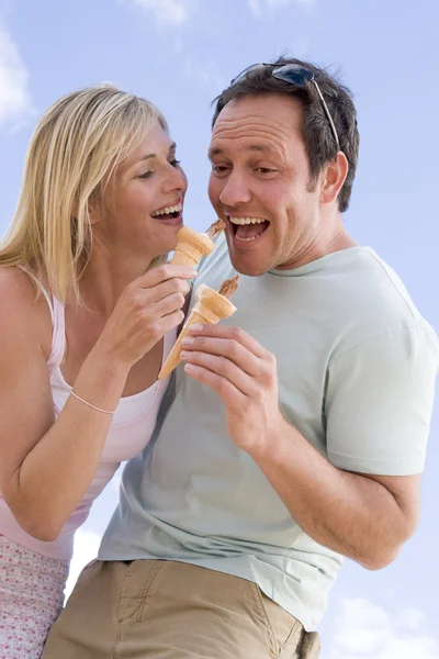 カップルの屋外アイス クリームを食べると笑みを浮かべて — ストック写真