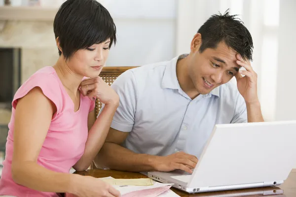 Couple in dining room with laptop looking unhappy — Stock Photo, Image