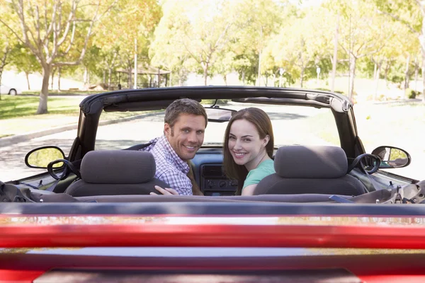 Couple en voiture convertible souriant — Photo