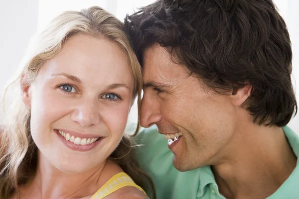 Par i vardagsrummet leende — Stockfoto