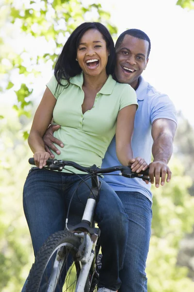 Koppel op een fiets buitenshuis glimlachen — Stockfoto