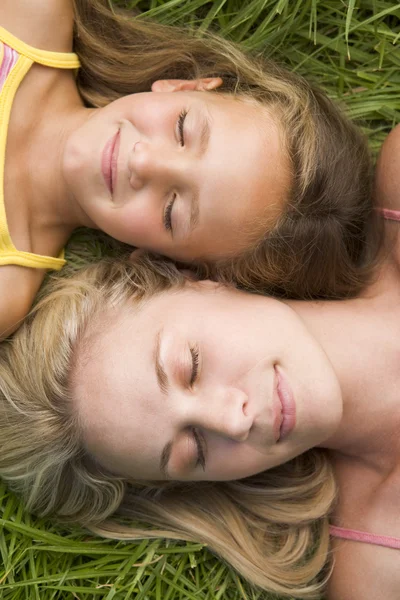 女人和年轻女孩躺在草睡 — 图库照片
