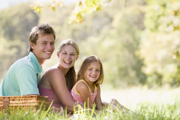 Familia en el parque haciendo un picnic y sonriendo —  Fotos de Stock