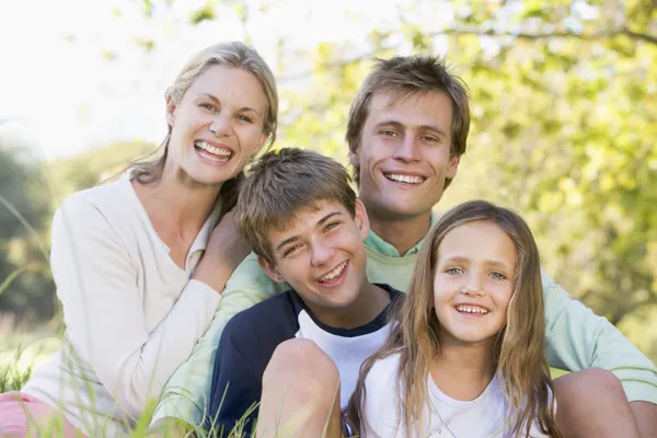 Family Sitting Outdoors Smiling — Stock Photo, Image