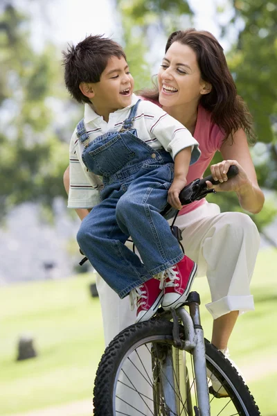 女人和年轻男孩骑自行车户外微笑 — 图库照片