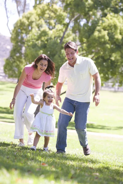 Familia corriendo al aire libre sonriendo — Foto de Stock