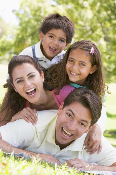 Familia acostada al aire libre sonriendo — Foto de Stock