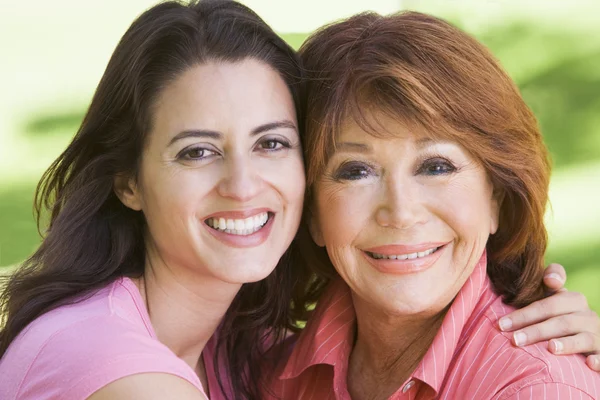 Dwie kobiety, stojący na zewnątrz uśmiechający się — Zdjęcie stockowe