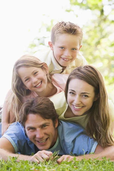 Family lying outdoors smiling — Stok fotoğraf