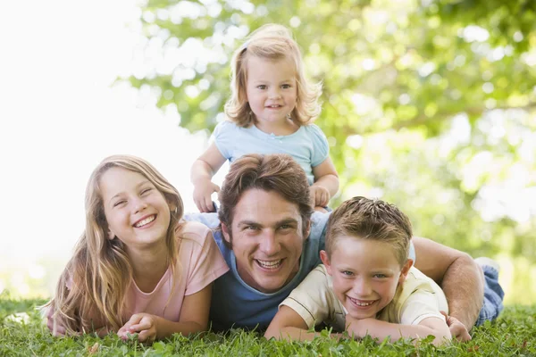 Family lying outdoors smiling — Stok fotoğraf