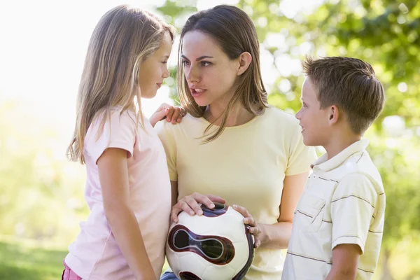 Woman and two young children outdoors holding volleyball and smi — Stock Photo, Image