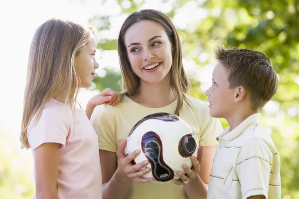 女人和两个年幼的孩子户外活动举行排球和 Smi — 图库照片