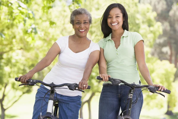 两名妇女骑自行车户外微笑 — 图库照片