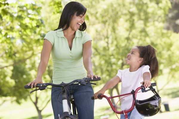 Γυναίκα και τους νέους κορίτσι με τα ποδήλατα που είναι χαμογελώντας σε εξωτερικούς χώρους — Φωτογραφία Αρχείου