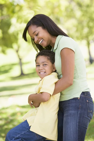 Mulher e menino ao ar livre abraçando e sorrindo — Fotografia de Stock