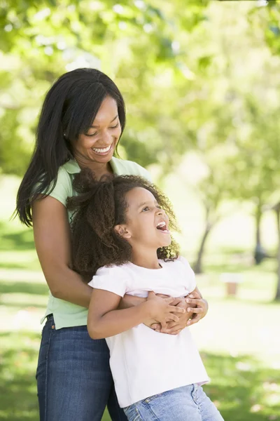 Kvinna och unga flicka utomhus embracing och leende — Stockfoto