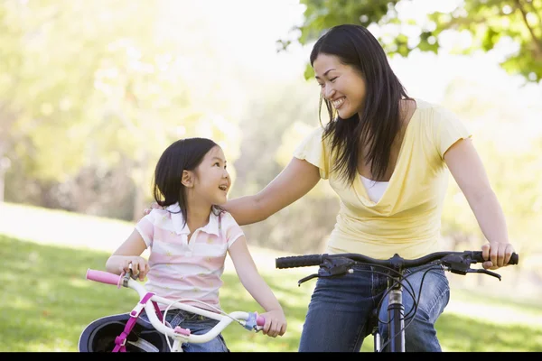 骑自行车户外微笑的女人和年轻女孩 — 图库照片