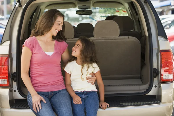 Женщина с молодой девушкой, сидящей на заднем сиденье фургона улыбаясь — стоковое фото