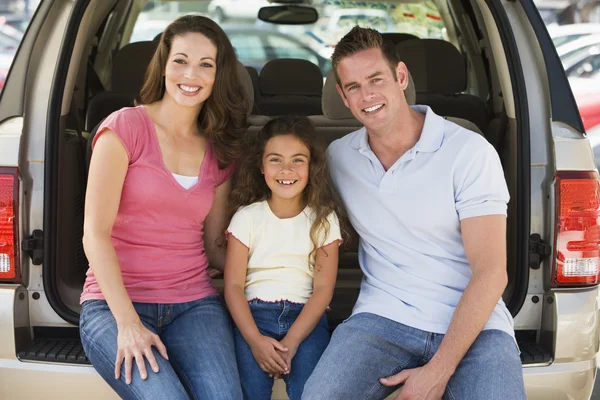 Familia sentada en la parte trasera de la camioneta sonriendo — Foto de Stock
