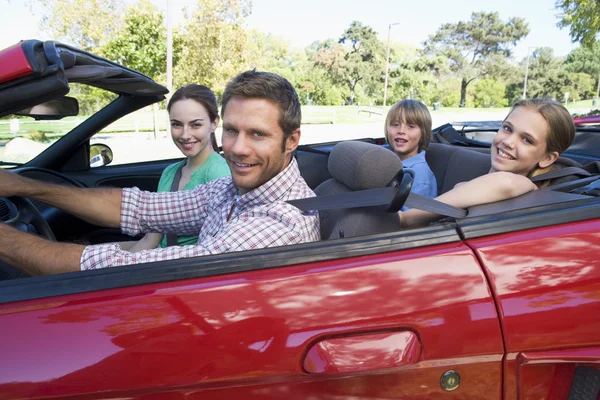 Famille en voiture convertible souriant — Photo