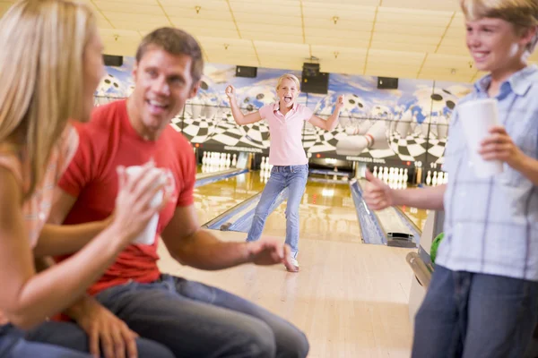Family in bowling alley cheering and smiling — Stock Photo, Image