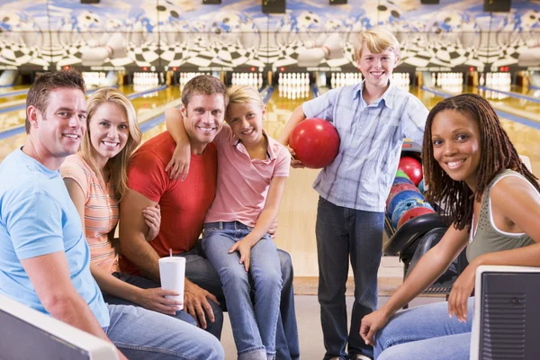 Сім'я в боулінг алеї з двома друзями посміхається — стокове фото